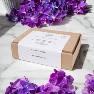 Podgrzewacze zapachowe w kartonie z białą etykietą i fioletowymi kwiatami w tle.