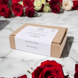 Tekturowe opakowanie z tealightami sojowymi z czerwonymi różami w tle.