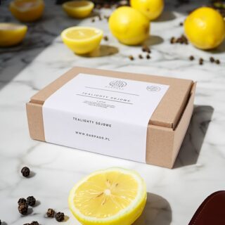 Tealighty naturalne w kartonie z etykietą z cytrynami i pieprzem na białym blacie.